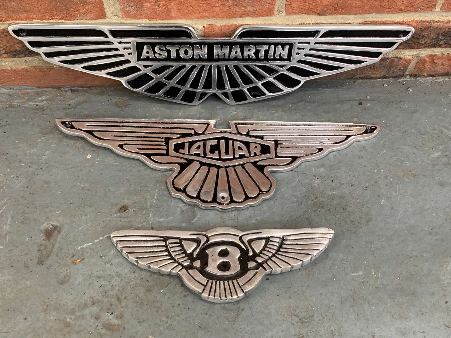 <p>Three Cast Aluminum Aston Martin/Bentley/Jaguar Emblem Signs</p>