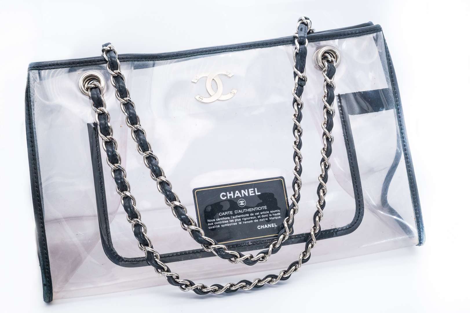 <p>CHANEL, PVC tote bag, with black leather trim and silver curb link chain carry strap. 2006-2008</p>