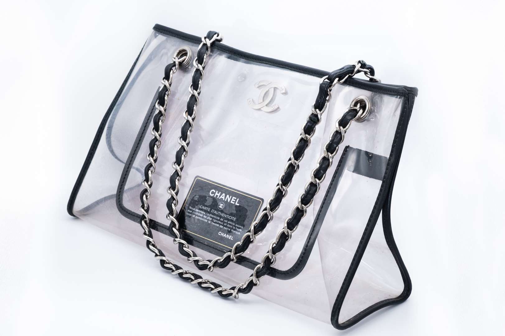 <p>CHANEL, PVC tote bag, with black leather trim and silver curb link chain carry strap. 2006-2008</p>