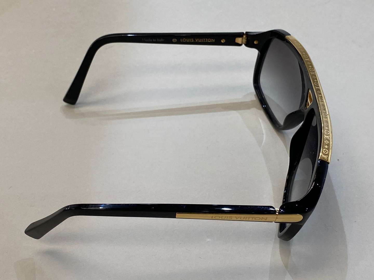 <p>LOUIS VUITTON, a pair of Italian, gilt mounted, black framed sunglasses</p>