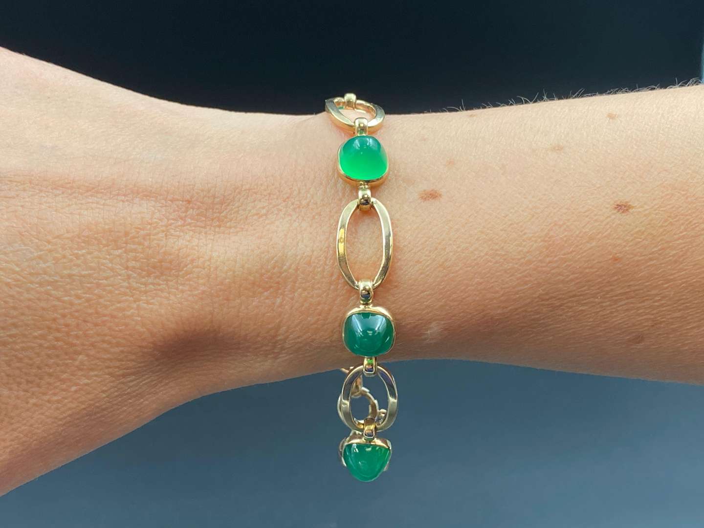 <p>An openwork bracelet set with 5 green glass cabochons.</p>