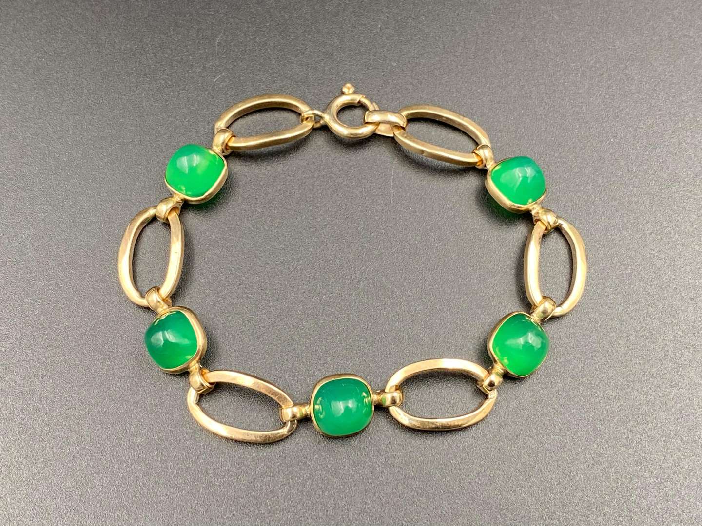 <p>An openwork bracelet set with 5 green glass cabochons.</p>