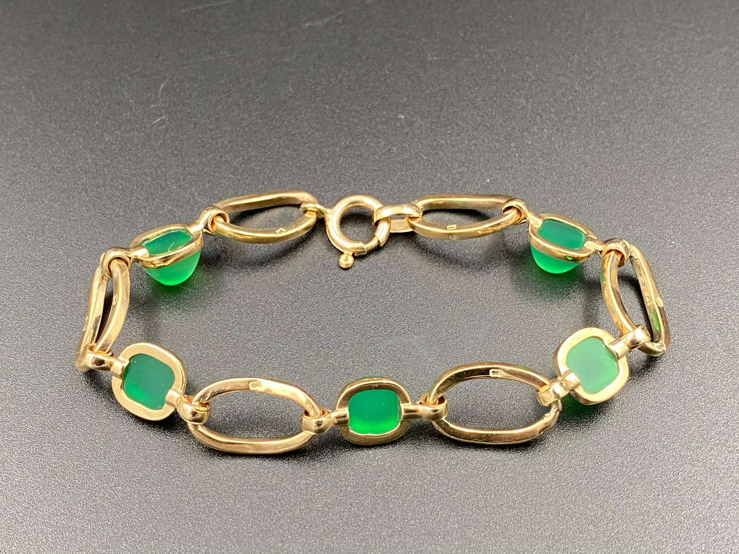 <p>An openwork bracelet set with 5 green glass cabochons.</p>