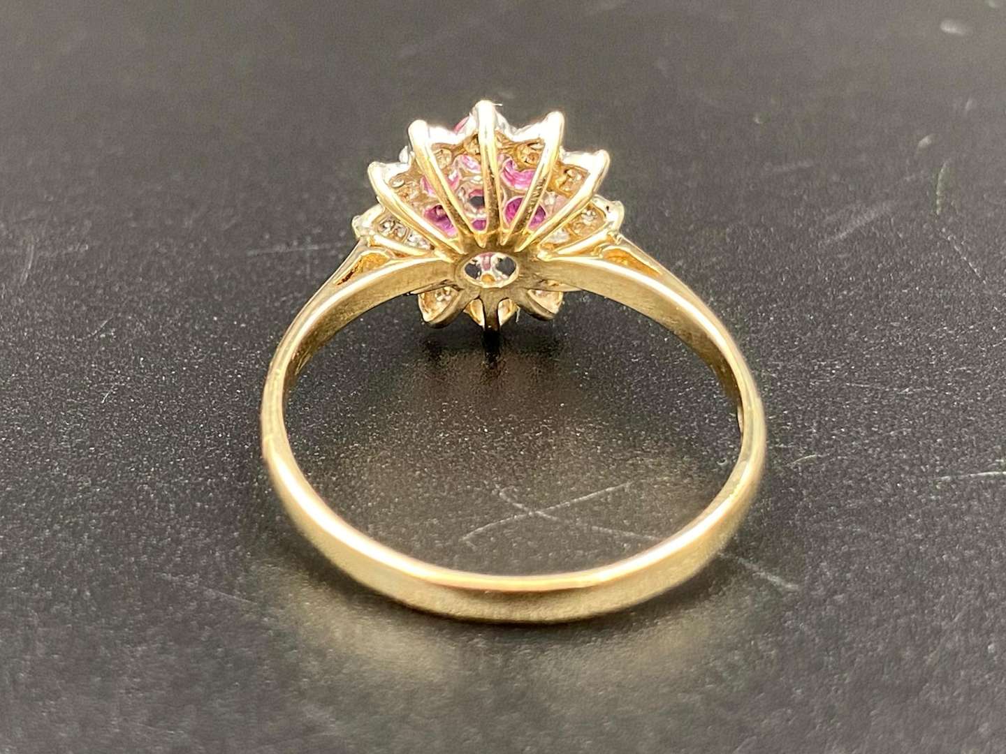 <p>A ruby and diamond flower head and 9ct yellow gold cluster ring.</p>