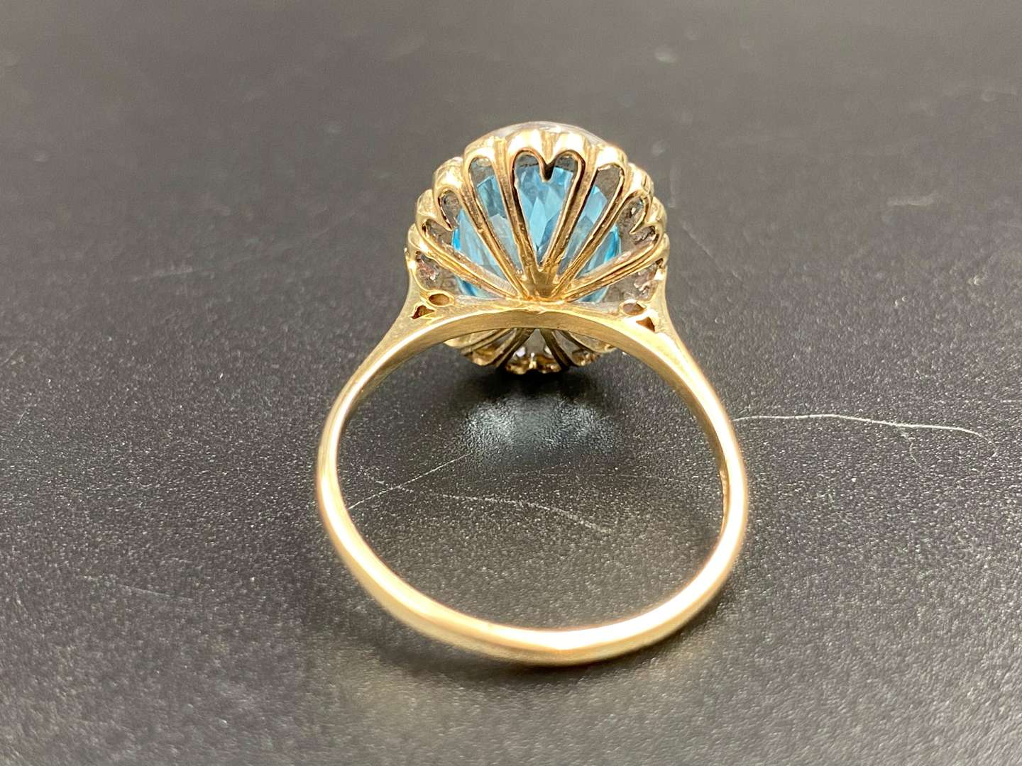 <p>A Swiss, blue topaz and diamond set, 9ct yellow gold, “Illusion” halo ring.</p>