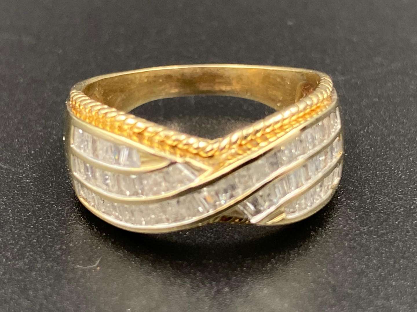 <p>A Diamond set, 9ct yellow gold, crossover band, with braided surround.</p>