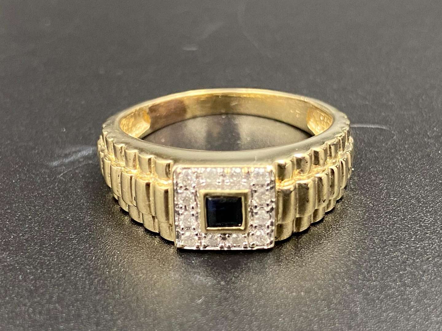 <p>A “Rolex” style, blue sapphire and 9ct yellow gold dress ring.</p>