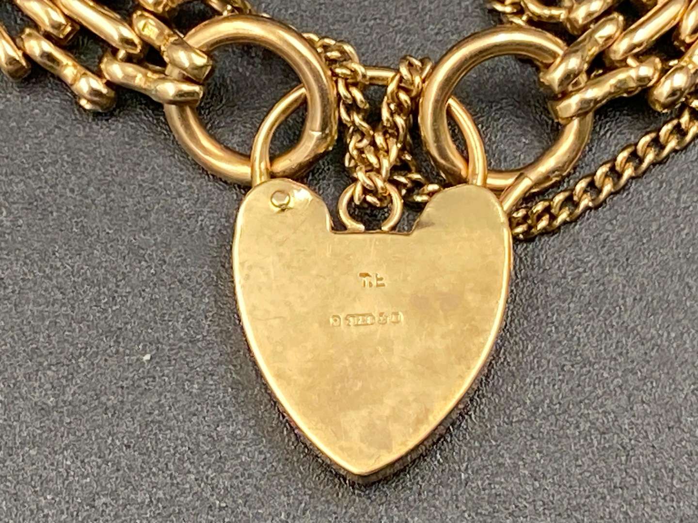 <p>A 9ct gold graduated gate link bracelet with heart shaped padlock clasp</p>